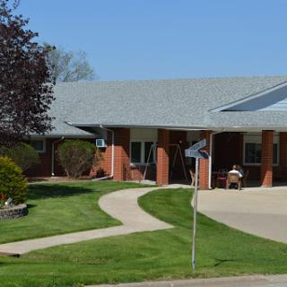A well-maintained residential building with a landscaped pathway and outdoor seating.