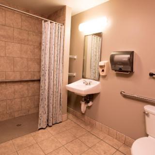 A clean and modern bathroom with a shower area, sink, and toilet.