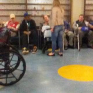 A group of elderly individuals waiting in a healthcare facility.
