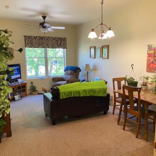 A cozy and inviting living space featuring a comfortable couch, a dining area, and plenty of natural light.