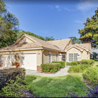 A suburban single-story house with well-maintained landscaping and a spacious driveway.