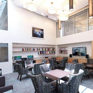 A spacious and modern lounge area with comfortable seating and bookshelves.