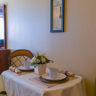 A cozy dining setup with two place settings and a floral centerpiece in a warmly lit room.