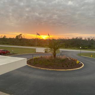 A serene sunset view with palm trees framing the scene.