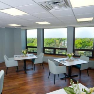 Modern dining area with large windows and contemporary furnishings.