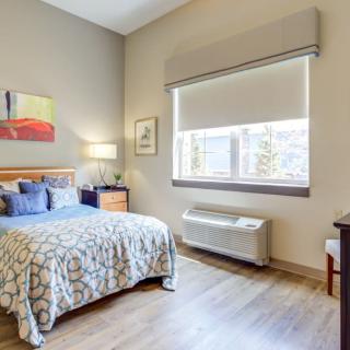 A modern bedroom with a comfortable bed, stylish furniture, and natural lighting.