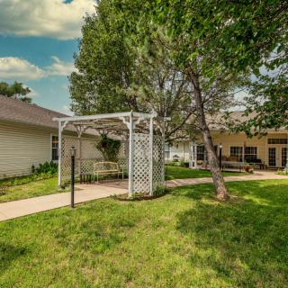 A serene backyard with a pergola and well-maintained lawn.