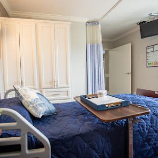 A well-equipped hospital patient room featuring a bed, medical furnishings, and a comfortable environment.
