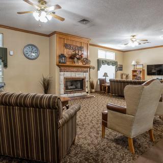 A cozy living room with a fireplace, comfortable seating, and warm decor.