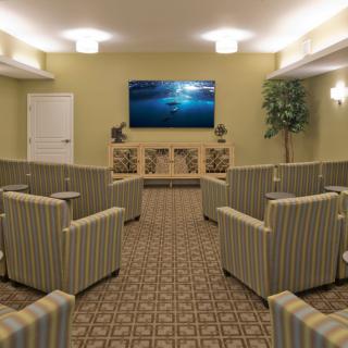 A cozy home theater room featuring striped seating and a large wall-mounted TV.