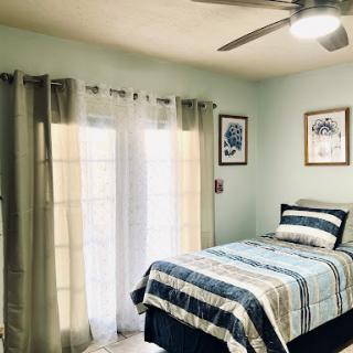 A cozy and inviting bedroom featuring a neatly made bed, soft curtains, and tasteful decor.