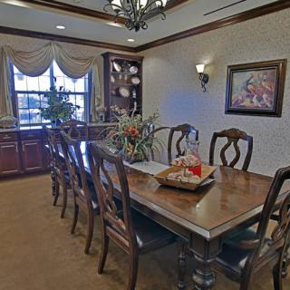 A spacious dining room with a large wooden table and elegant decor.
