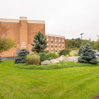 A serene view of a hotel exterior surrounded by well-maintained landscaping and greenery.
