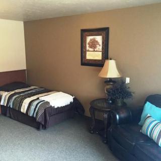 A cozy bedroom with a single bed, side table, and decorative elements.