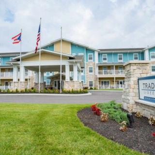 A modern hotel building with landscaped surroundings and flags at the entrance.