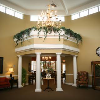 A welcoming and elegant lobby featuring a chandelier and decorative columns.