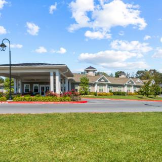 A scenic view of a building with a well-maintained lawn and a clear blue sky.