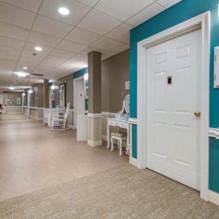 A well-lit hallway with doors and seating areas.