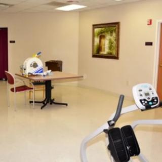 An empty room with exercise equipment and a painting on the wall.