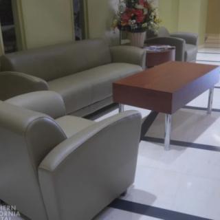 A modern lobby seating area featuring a sofa, armchair, and coffee table.