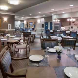 A well-arranged dining area with neatly set tables and chairs, ready for guests.