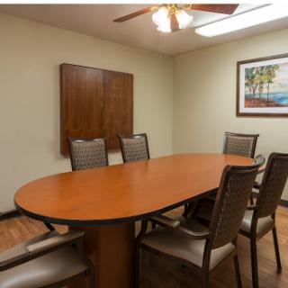 A well-furnished conference room with a round table and comfortable chairs, ideal for meetings and discussions.