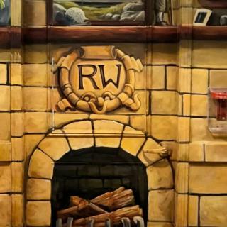 A decorative stone fireplace featuring an 'RW' logo above the hearth.