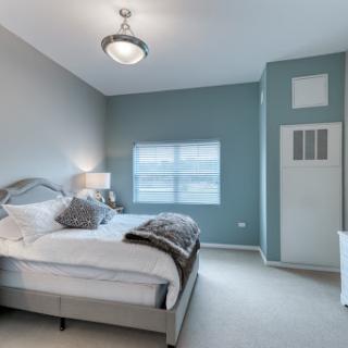 A cozy, modern bedroom featuring soft color tones and comfortable furnishings.