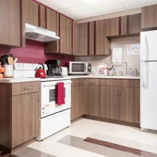 A modern kitchen with wooden cabinets and various appliances.