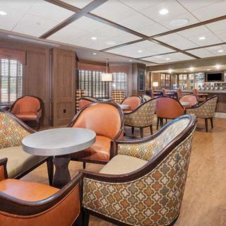 A cozy lounge area with comfortable seating and a bar in the background.