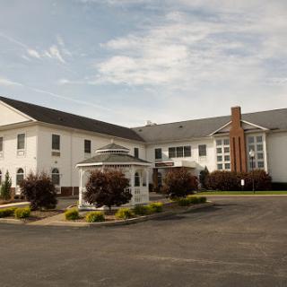 A view of a modern building with a white exterior and landscaped surroundings.