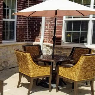 A cozy outdoor patio setup with wicker chairs and a large umbrella.