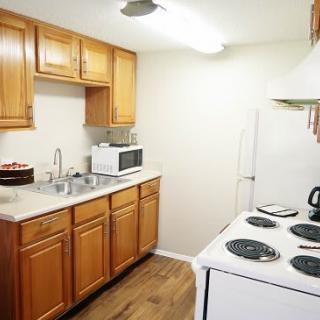 A cozy kitchen with wooden cabinets, white appliances, and a clean countertop.