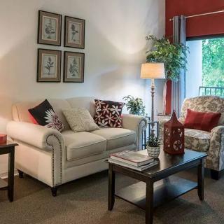 A cozy living room with comfortable seating, stylish decor, and warm lighting.