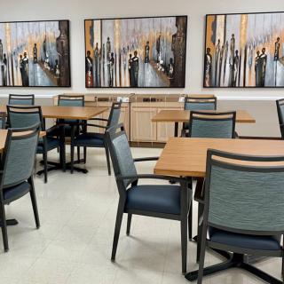 A modern dining area featuring several tables and chairs with abstract artwork on the walls.