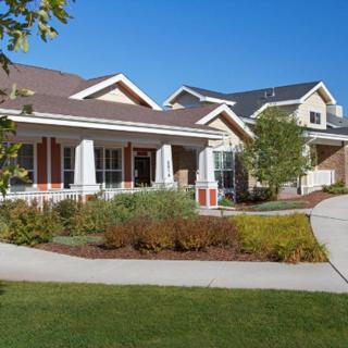 A well-maintained residential building with a lush lawn and landscaped garden.