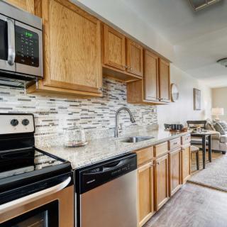 A modern kitchen featuring wood cabinets, stainless steel appliances, and a stylish backsplash.