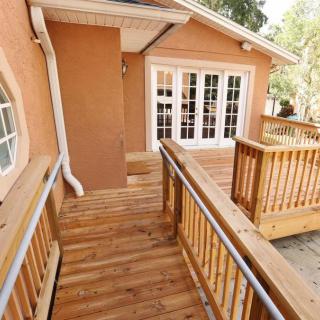 A wooden ramp leading to the entrance of a house, featuring railings and an accessible design.
