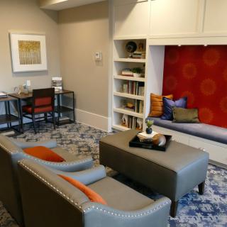 A modern living room featuring a cozy seating area with stylish furniture and a built-in bookshelf.
