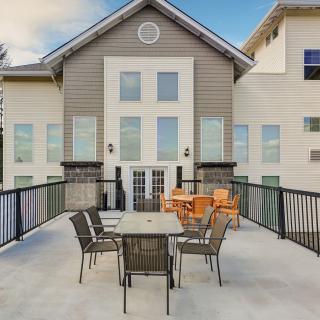 A modern building with a spacious patio featuring tables and chairs.