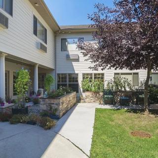 A sunny day in a landscaped courtyard with a patio area outside a residential building.