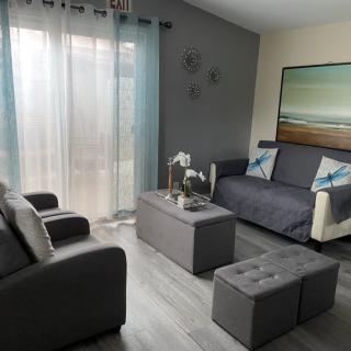 A modern, minimalist living room with a gray color scheme featuring a sofa, coffee table, and decorative elements.