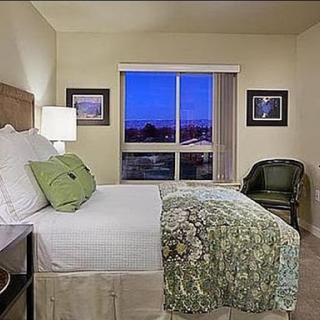 A cozy and well-decorated bedroom with a view at dusk.