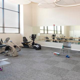 A clean and minimalistic gym with exercise equipment including stationary bikes.