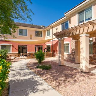 A sunny residential courtyard with pathways and lush greenery.