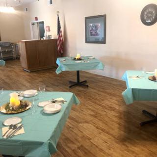 A spacious dining area set up with turquoise tablecloths, ready for a gathering or event.