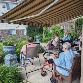A group of elderly individuals enjoying a sunny day in the garden.