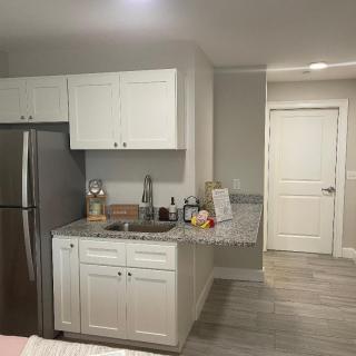 A modern kitchen with white cabinets and stainless steel appliances.
