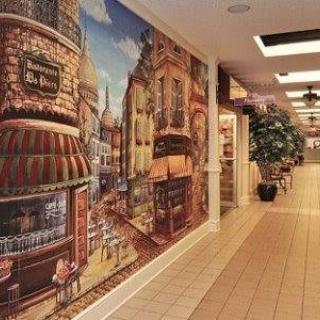 A hallway featuring a vibrant wall mural depicting a charming street scene with buildings.