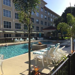 A sunny day at a residential complex with a swimming pool and outdoor seating.